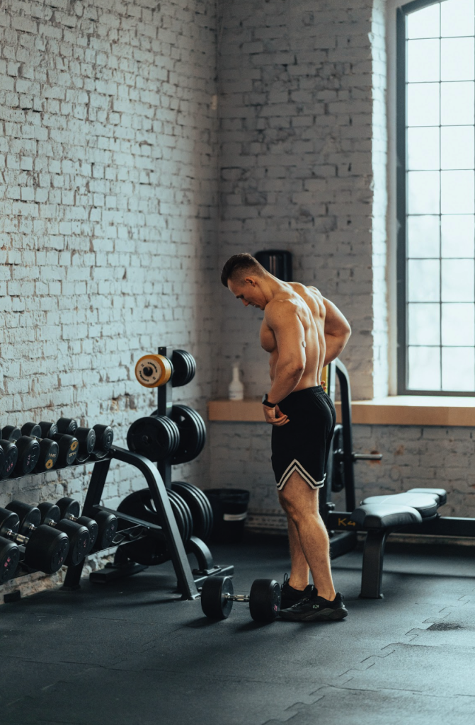 Mężczyzna na siłowni przygotowuje się do ćwiczeń z hantlami